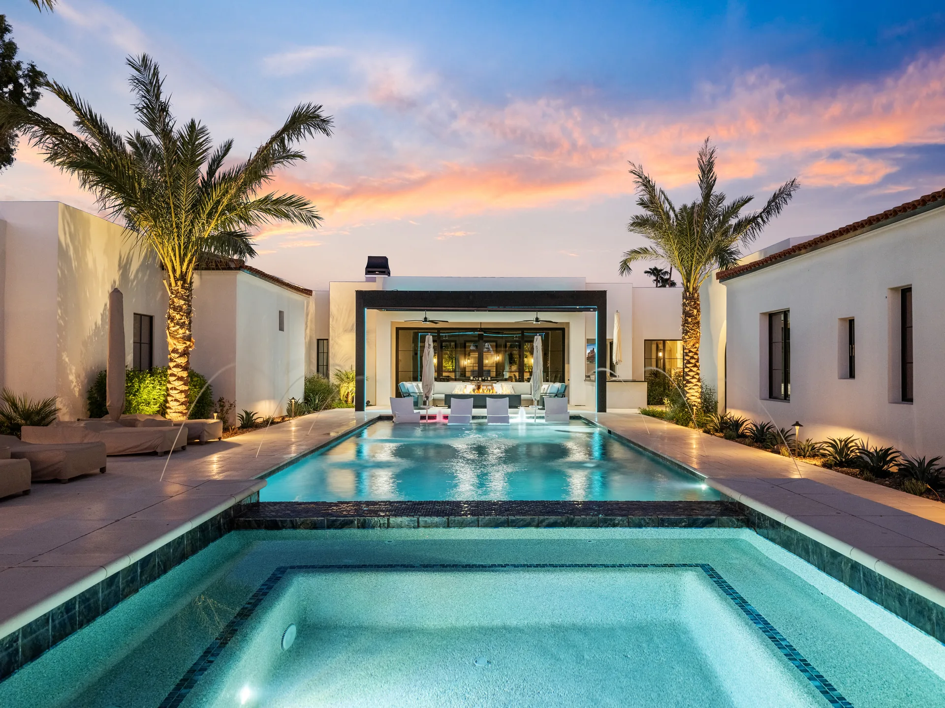 Modern slim-frame pergola beyond a swimming pool at sunset, illustrating contemporary backyard shade systems
